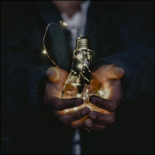 手で電球を持った画像です